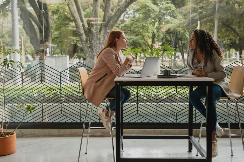How to Open a Trading Account with a Broker in the UK 12 Two women at a desk chatting